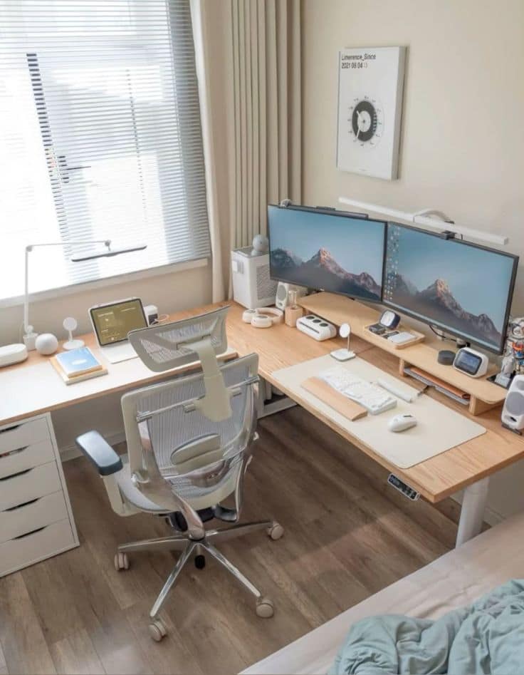 a desk with two computers and a chair